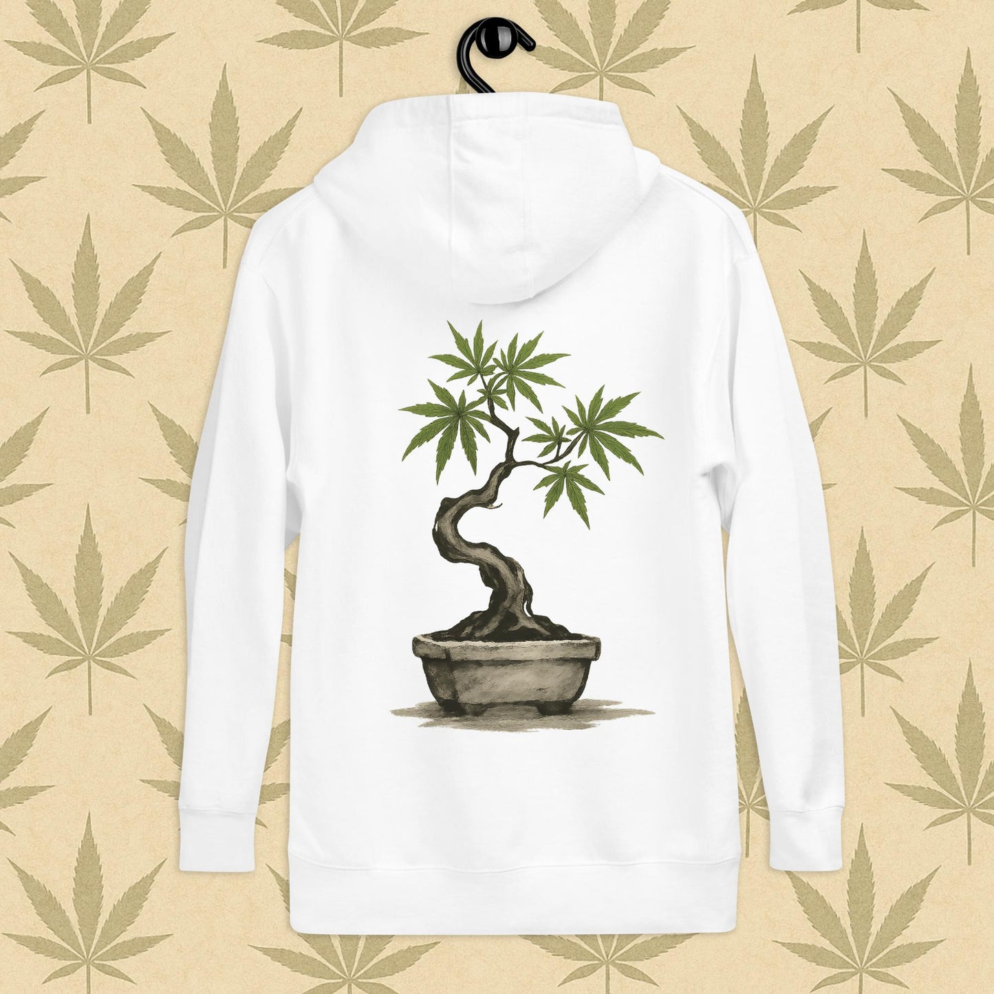 Back view of a white-colored unisex premium hoodie featuring a large Japanese sumi-e style cannabis-bonsai illustration centered on the garment against a neutral leaf backdrop.