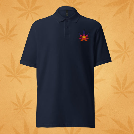 Sport-navy pique polo shirt with a small embroidered sunset-colored cannabis leaf emblem on the left chest; front view against a warm desert-orange leaf backdrop.