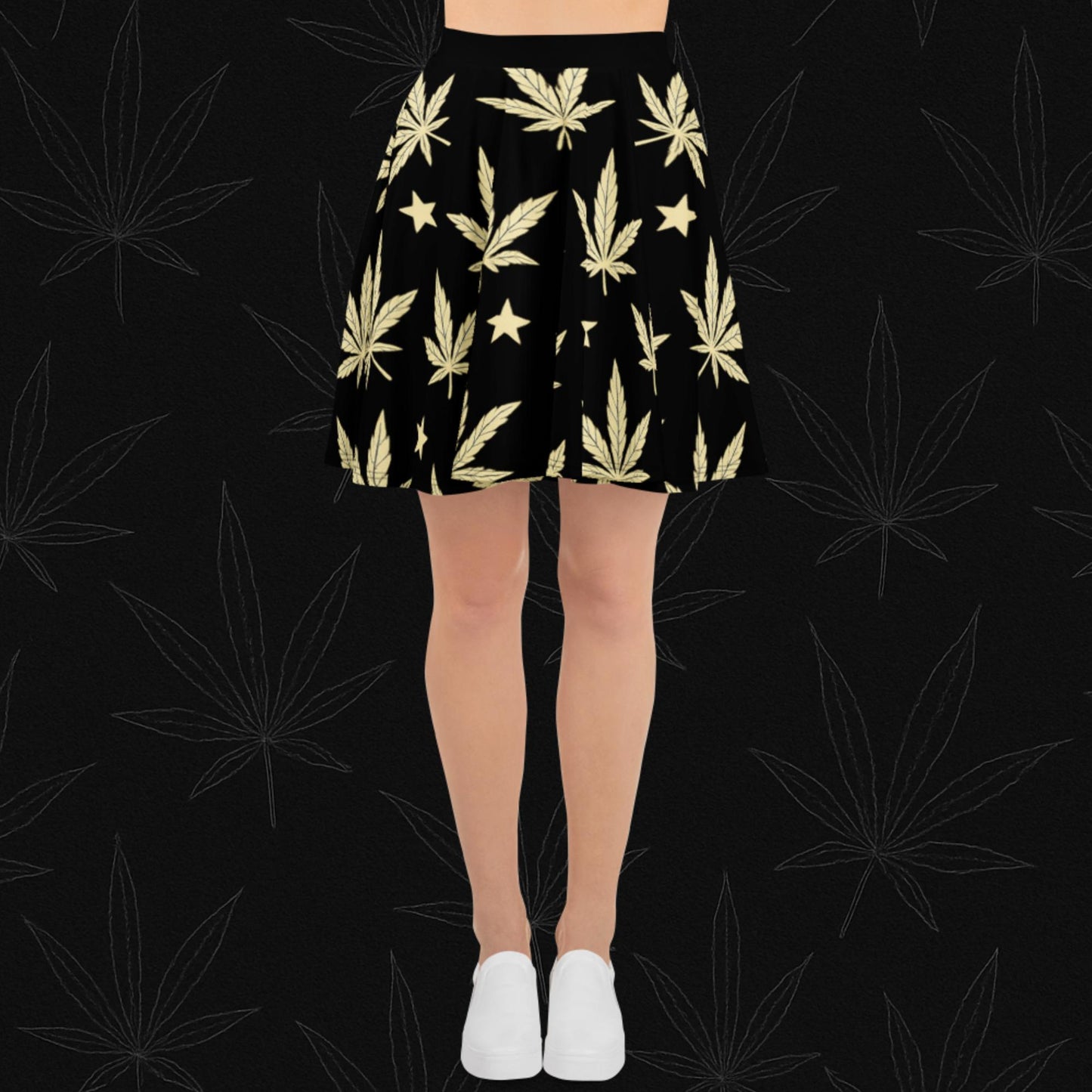 Chill Monkey all-over print skater skirt with golden cannabis leaves and stars, streetwear 420 fashion, front view, black base.