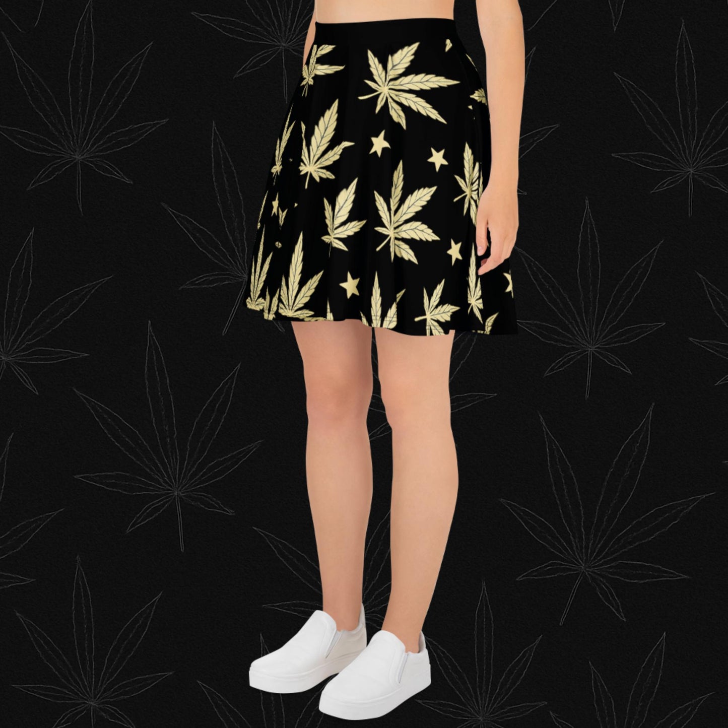 Chill Monkey all-over print skater skirt with golden cannabis leaves and stars, streetwear 420 fashion, front view, black base.