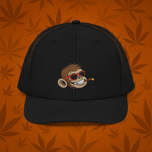 Chill Monkey snapback trucker cap with embroidered Chill Monkey mascot smoking cannabis joint, streetwear 420 accessory, heather-black front and black mesh, front view.