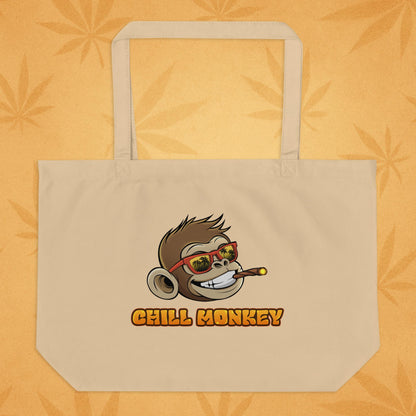 Back view of the same oyster-sand eco tote featuring the smiling Chill Monkey head in red sunglasses and the text “CHILL MONKEY,” displayed on a warm desert-leaf backdrop
